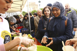 People line up to get a cup of fruit salad made with 'wasted' produce deemed unsuitable by food stores because of their appearance in the northern Greek city of Thessaloniki on Sunday, Nov. 9, 2014. More than 5,000 ate over 2 tons of perfectly edible produce in a 'Feeding5000' event organized by global CEO Feedback to highlight the waste of foodstuff in advanced societies. (AP Photo/Grigoris Siamidis)