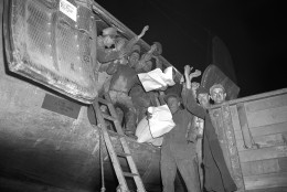 A cargo handling crew at Tempelhof airfield in Berlin pause in their task of unloading a Skymaster plane of the Berlin airlift, May 5, 1949 to raise a cheer over the news of the lifting of the German capital, scheduled for May 12. The airlift, however, is planned to be continued despite the proposed end of the Berlin siege. (AP Photo)