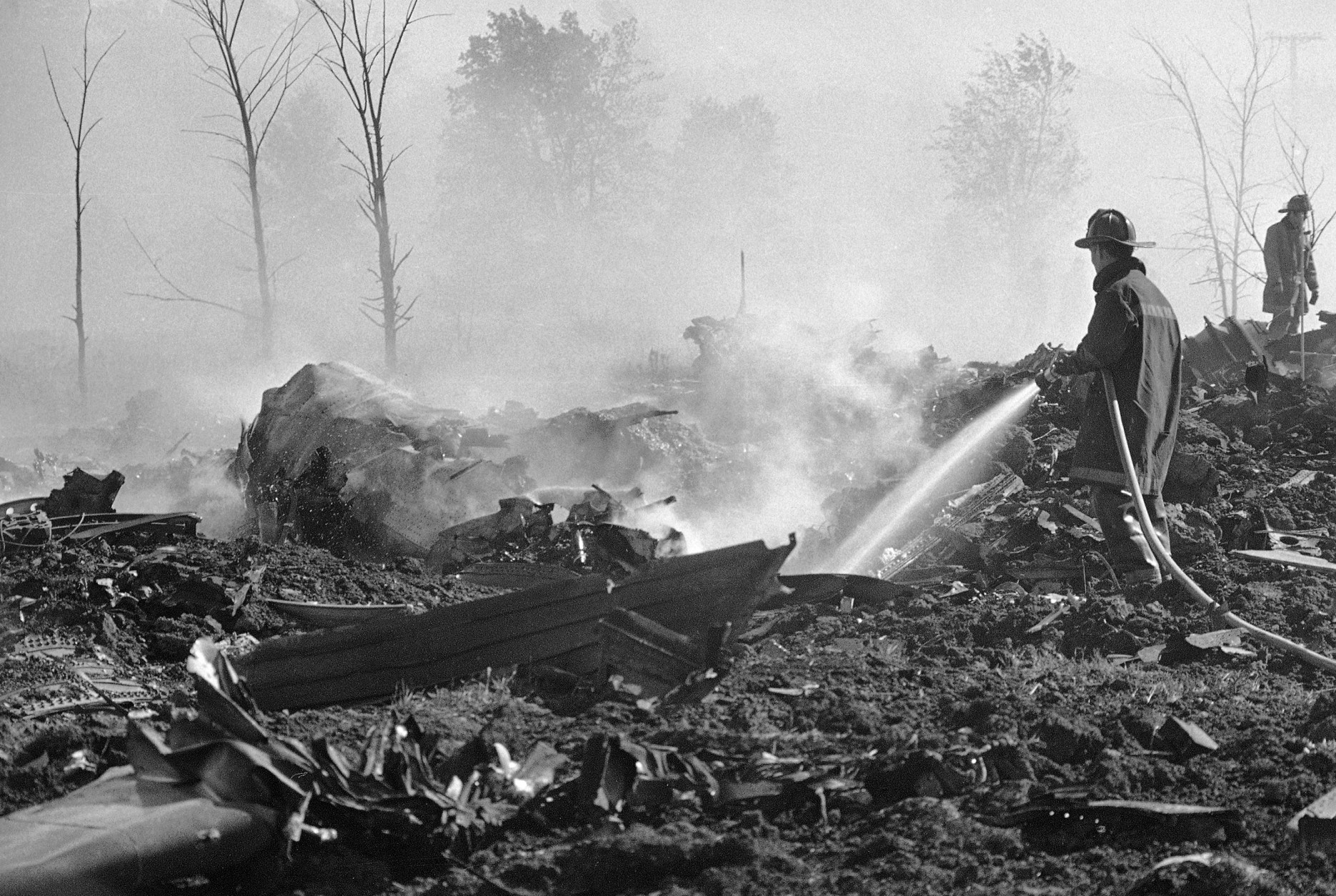 A fireman hoses down twisted remains of an American Airlines DC-10 which crashed and exploded on takeoff from O'Hare International Airport, killing 279 passengers, May 25, 1979.  (AP Photo/Fred Jewell)