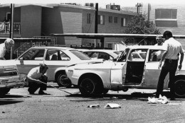 City and federal investigators examined a car damaged on Wednesday, June 3, 1976 in Phoenix, Ariz., in a bomb explosion which critically injured Arizona Republican investigative reporter Don Bolles, 47. (AP Photo)