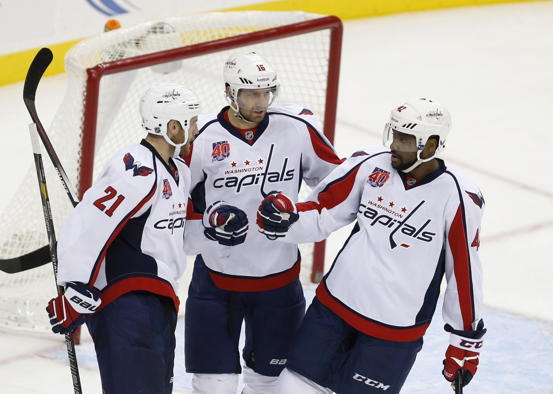 From left to right, former Washington Capitals' Brooks Laich, Eric Fehr and Joel Ward celebrate Laich's open-net goal against the New Jersey Devils during the third period of an NHL hockey game, Saturday, Dec. 6, 2014, in Newark, N.J. The Capitals won 4-1. (AP Photo/Julio Cortez)