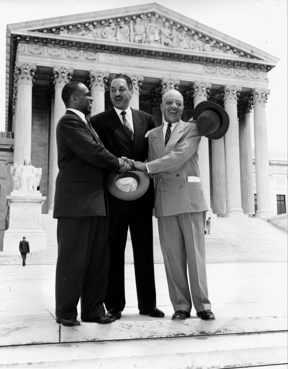 FILE - This May 17, 1954 file photo shows, from left, George E.C. Hayes, Thurgood Marshall, and James M. Nabrit joining hands as they pose outside the Supreme Court in Washington.  The three lawyers led the fight for abolition of segregation in public schools before the Supreme Court, which ruled today that segregation is unconstitutional. On May 17, 1954, a hushed crowd of spectators packed the Supreme Court, awaiting word on Brown v. Board of Education, a combination of five lawsuits brought by the NAACP's legal arm to challenge racial segregation in public schools. The high court decided unanimously that "separate but equal" education denied black children their constitutional right to equal protection under the law, effectively removing a cornerstone that propped up Jim Crow, or state-sanctioned segregation of the races. (AP Photo, File)