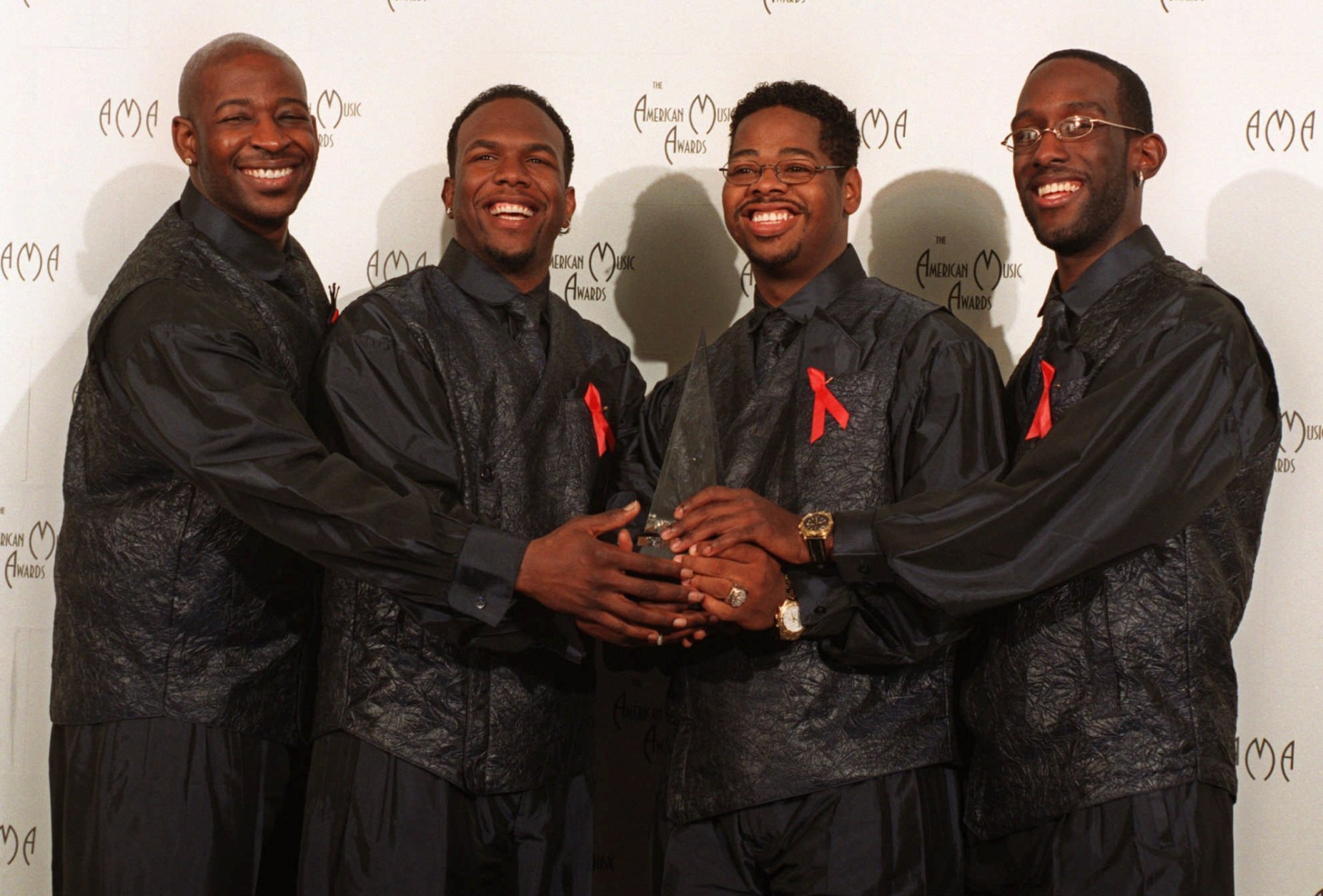 Members of Boyz II Men are shown after winning the award for Best Soul/Rhythm and Blues Group at the 25th annual American Music Awards at the Shrine Auditorium in Los Angeles, Monday, Jan. 26, 1998.  The band members are Michael McCary, Nathan Morris, Wanya Morris and Shawn Stockman. (AP Photo/Michael Caulfield)