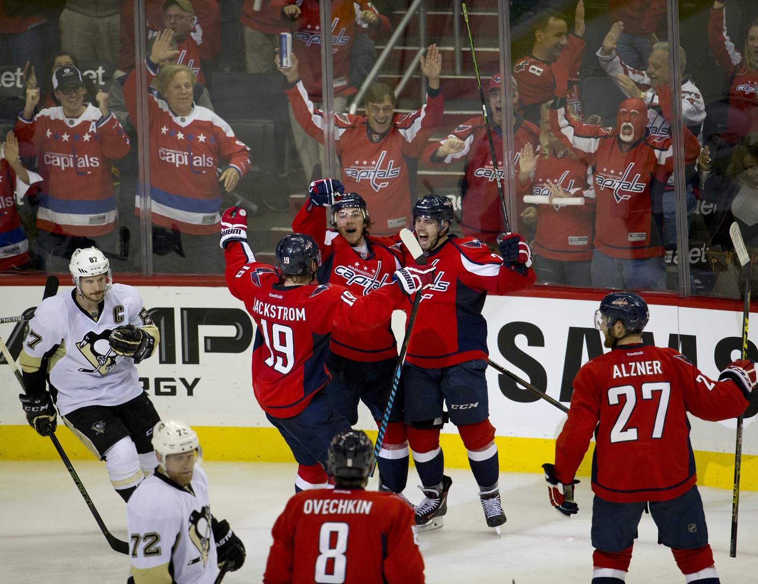 Washington Capitals T.J. Oshie (77) celebrates his second goal against Pittsburgh Penguins with teammates Nicklas Backstrom (19) and Karl Alzner (27), during the third period of Game 1 in an NHL hockey Stanley Cup Eastern Conference semifinal series Thursday, April 28, 2016, in Washington. The Capitals won 4-3 in overtime. (AP Photo/Pablo Martinez Monsivais)