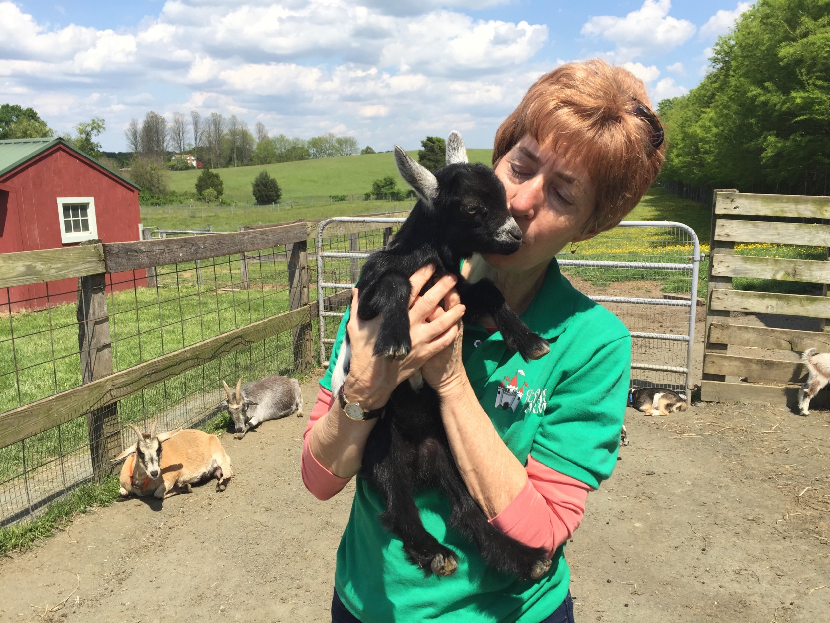 Martha Clark cuddles with the youngest goat on the farm. Hillary is only two weeks old! (WTOP/Michelle Basch)
