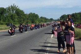 Onlookers along Route 10 in Maryland wave flags at passing motorcycles on their way to Rolling Thunder on Sunday, May 29. (Darci Marchese/WTOP)