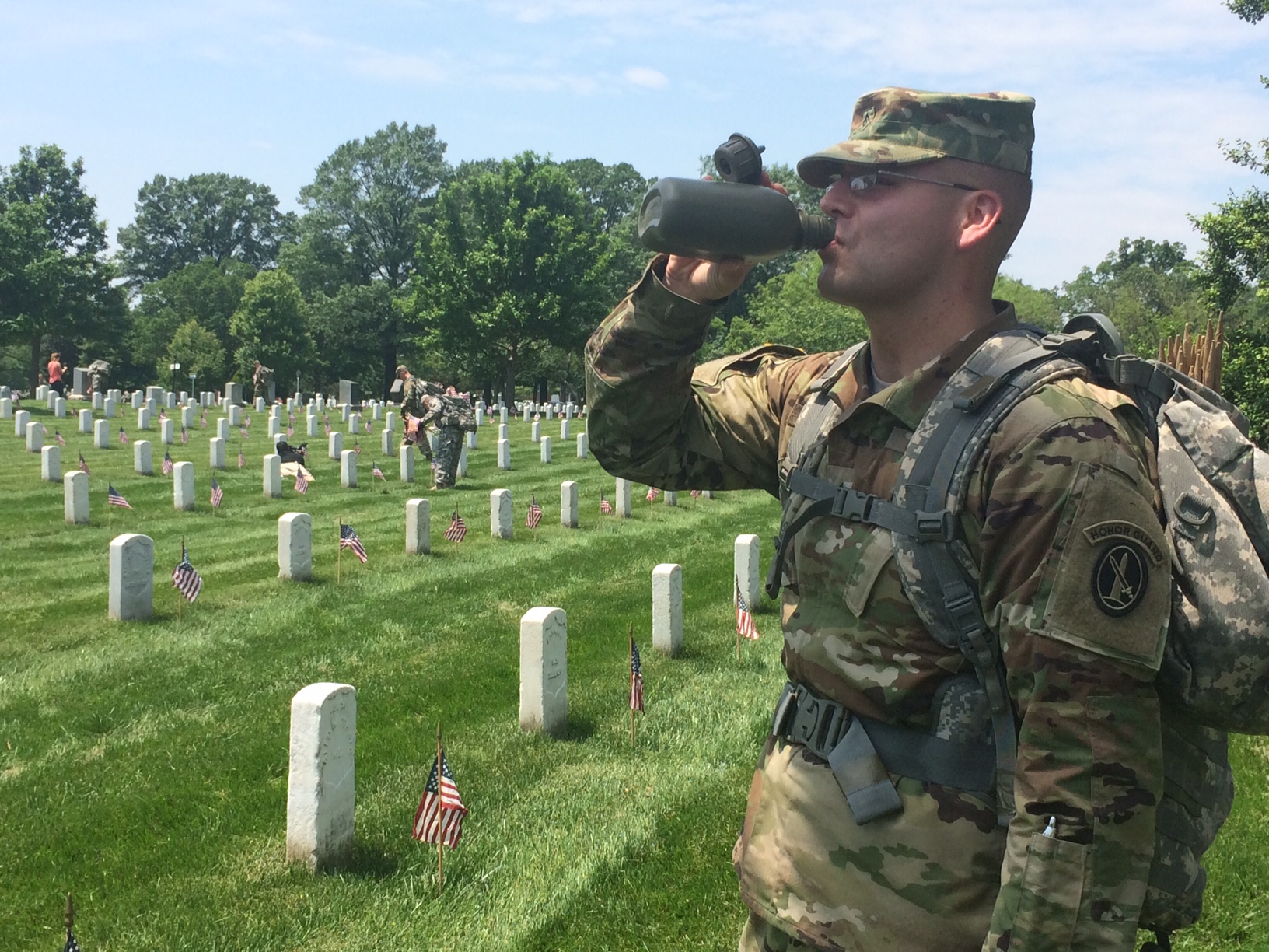 A soldier takes a drink of water during the annual "Flags-In" event on Thursday, May 26, 2016 at Arlington National Cemetery. Soldiers spent 4 hours in 90-degree heat placing hundreds of thousands of American flags to honor fallen soldiers. (WTOP/Rachel Nania)