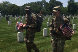 Soldiers in the 3rd U.S. Infantry Regiment carry flags through Arlington National Cemetery on Thursday, May 26, 2016. Before Memorial Day weekend each year, the Old Guard places hundreds of thousands of flags at the cemetery to honor fallen soldiers. (WTOP/Rachel Nania)