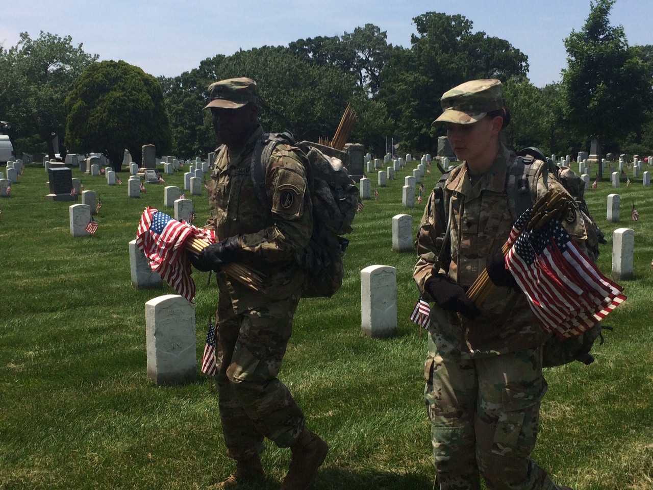 Soldiers in the 3rd U.S. Infantry Regiment carry flags through Arlington National Cemetery on Thursday, May 26, 2016. Before Memorial Day weekend each year, the Old Guard places hundreds of thousands of flags at the cemetery to honor fallen soldiers. (WTOP/Rachel Nania)