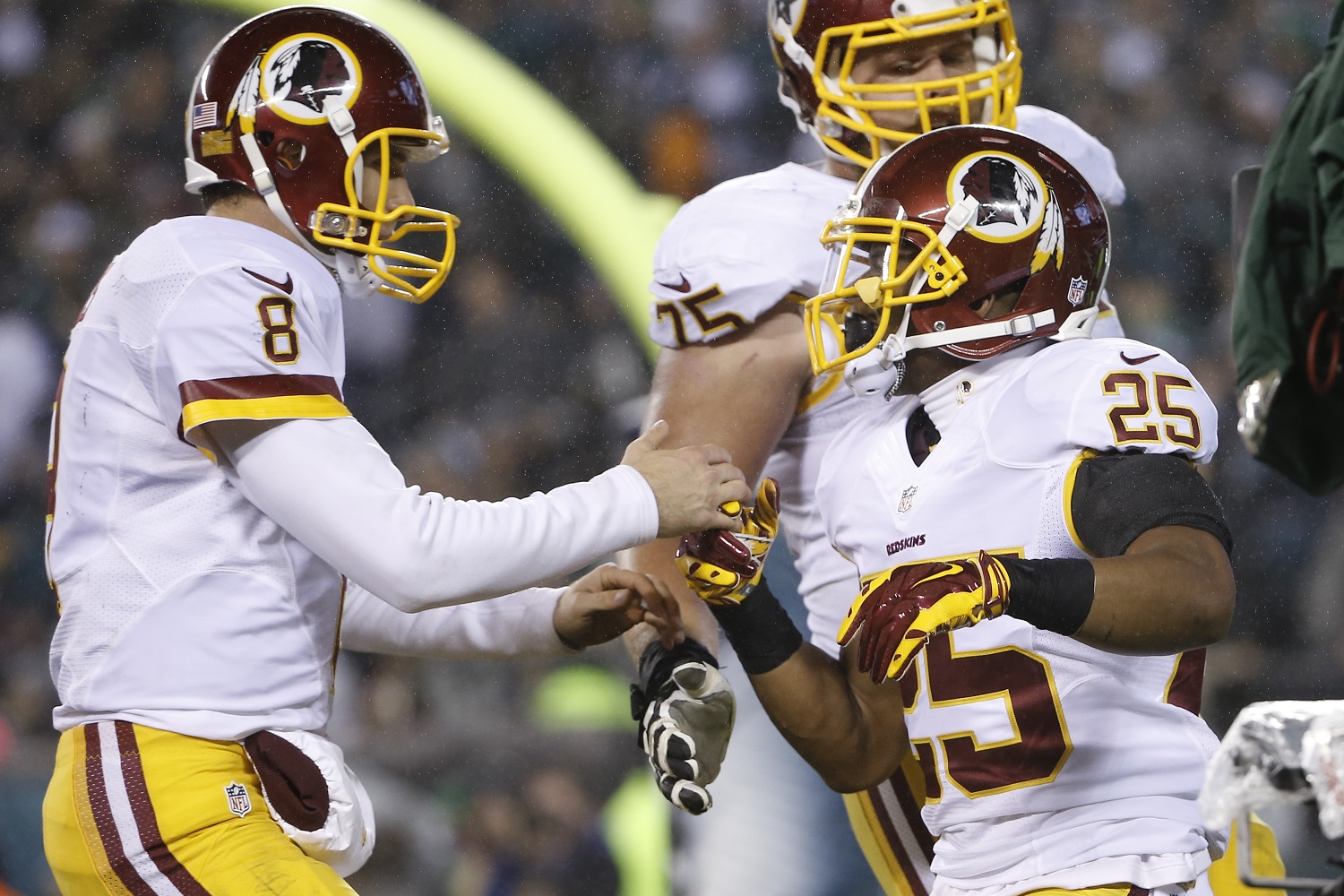 Washington Redskins' Kirk Cousins (8) and Chris Thompson (25) celebrate after Thompson's touchdown in the second half of an NFL football game against the Philadelphia Eagles, Saturday, Dec. 26, 2015, in Philadelphia.  (AP Photo/Matt Rourke)
