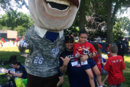 Nationals' Racing President Theodore Roosevelt poses with a child at Yellow Ribbon United and TAPS event. (WTOP/Dick Uliano)