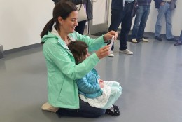 Donna McNamara takes pictures of her daughter Lila McNamara as she test drives a Tesla car for kids Sunday, May 22, 2106 at Tesla Motors Tyco Road in Vienna, Va. Her daughter, Avery McNamara, 4, is sitting in her lap waiting for her turn to test out the Tesla. (WTOP/Kathy Stewart)