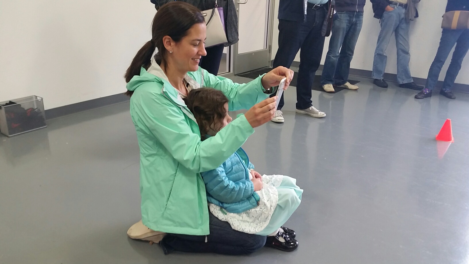 Donna McNamara takes pictures of her daughter Lila McNamara as she test drives a Tesla car for kids Sunday, May 22, 2106 at Tesla Motors Tyco Road in Vienna, Va. Her daughter, Avery McNamara, 4, is sitting in her lap waiting for her turn to test out the Tesla. (WTOP/Kathy Stewart)