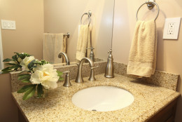 Modern bathroom vanity with beige granite top and faucets (Getty Images/iStockphoto/bukharova)