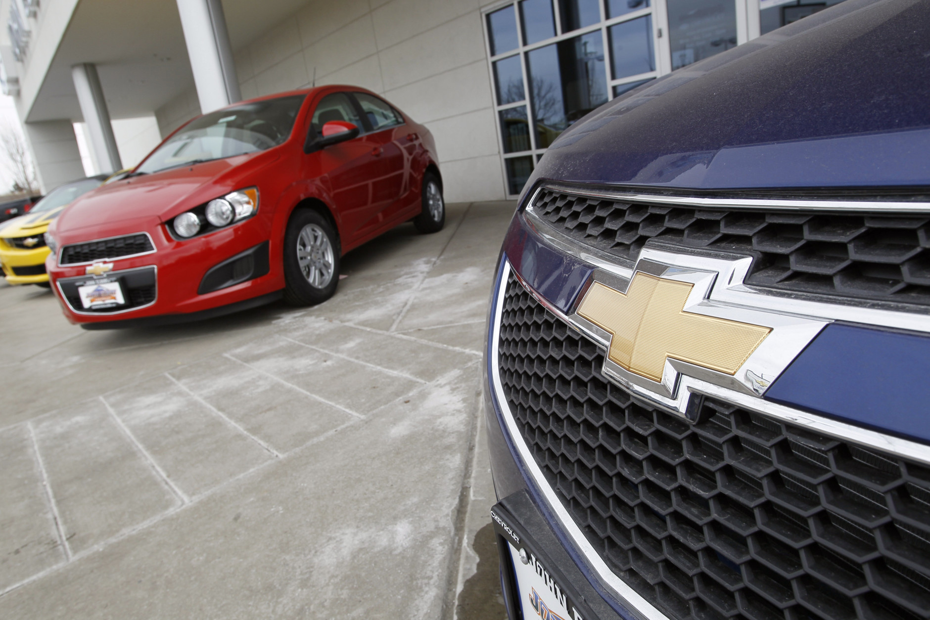 This Feb. 19, 2012 photo, shows the familiar Chevrolet bowtie logo displayed on the grille of a 2012 Cruze sedan (foreground) with a 2012 Sonic sedan in the background at a Chevrolet dealership in the south Denver suburb of Englewood, Colo. (AP Photo/David Zalubowski)