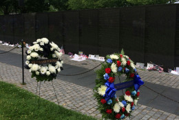 Floral wreaths rest next to the Vietnam Veterans Memorial. A ceremony to honor those who lost their lives during the Vietnam War was held at the memorial Monday. (WTOP/Dick Uliano)