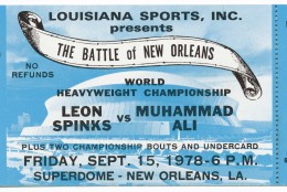 Ticket to the World Heaveywieght Championship boxing match between Muhammad Ali and Leon Spinks. The ticket is blue with black text. An image of the Superdome can be seen on the ticket. The text on the ticket starts with "LOUISIANA SPORTS, INC. / PRESENTS / THE BATTLE of NEW ORLEANS..."