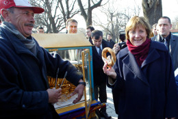 Angela Merkel, the leader of Germany's Christian Democrats, right, receives a simit, a traditional Turkish pretzel, from a street vendor as she tours Istanbul's old city, Turkey, Tuesday Feb. 17 , 2004. Angela Merkel is in Turkey for a two-day official visit. Merkel met with Turkish Prime Minister Recep Tayyip Erdogan and the other officials focusing on Turkey's European Union bid. (AP Photo/Osman Orsal)