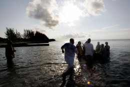A group of men wade into the ocean as they push a small raft loaded with offerings to their ancestors out to sea Sunday, June 19, 2005 on Virginia Key, Miami's former "black only" beach. The ceremony is part of the Juneteenth celebration, an unofficial black holiday that marks the day on June 19, 1865 when slaves in Texas learned that Abraham Lincoln had signed the Emancipation Proclamation two years earlier. (AP Photo/Wilfredo Lee)