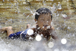 A boy tries to beat summer heat with splashed water at a Tokyo park Saturday, July 17, 2010. The Japan Meteorological Agency on Saturday said the temperature in central Tokyo shot up to 31 degrees Celsius (88 F) at noon as the weather men declared the rainy season seemed to be over in many parts of the nation, including the Tokyo area. (AP Photo/Koji Sasahara)