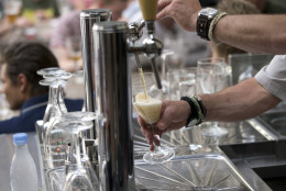 A worker pours a glass of beer for customers at the Halve Maan Brewery in Bruges, Belgium on Thursday, May 26, 2016. The brewery has recently created a beer pipeline which will ship beer straight from the brewery to the bottling plant, two kilometers away, through underground pipes running between the two sources. (AP Photo/Virginia Mayo)
