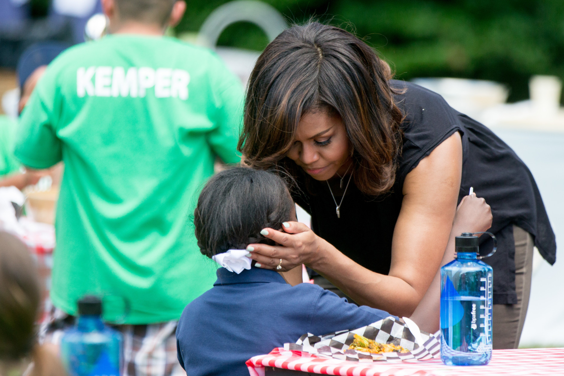 First lady Michelle Obama speaks with a child as school children from across the country help harvest the White House Kitchen Garden, Monday, June 6, 2016, at the White House in Washington. (AP Photo/Andrew Harnik)