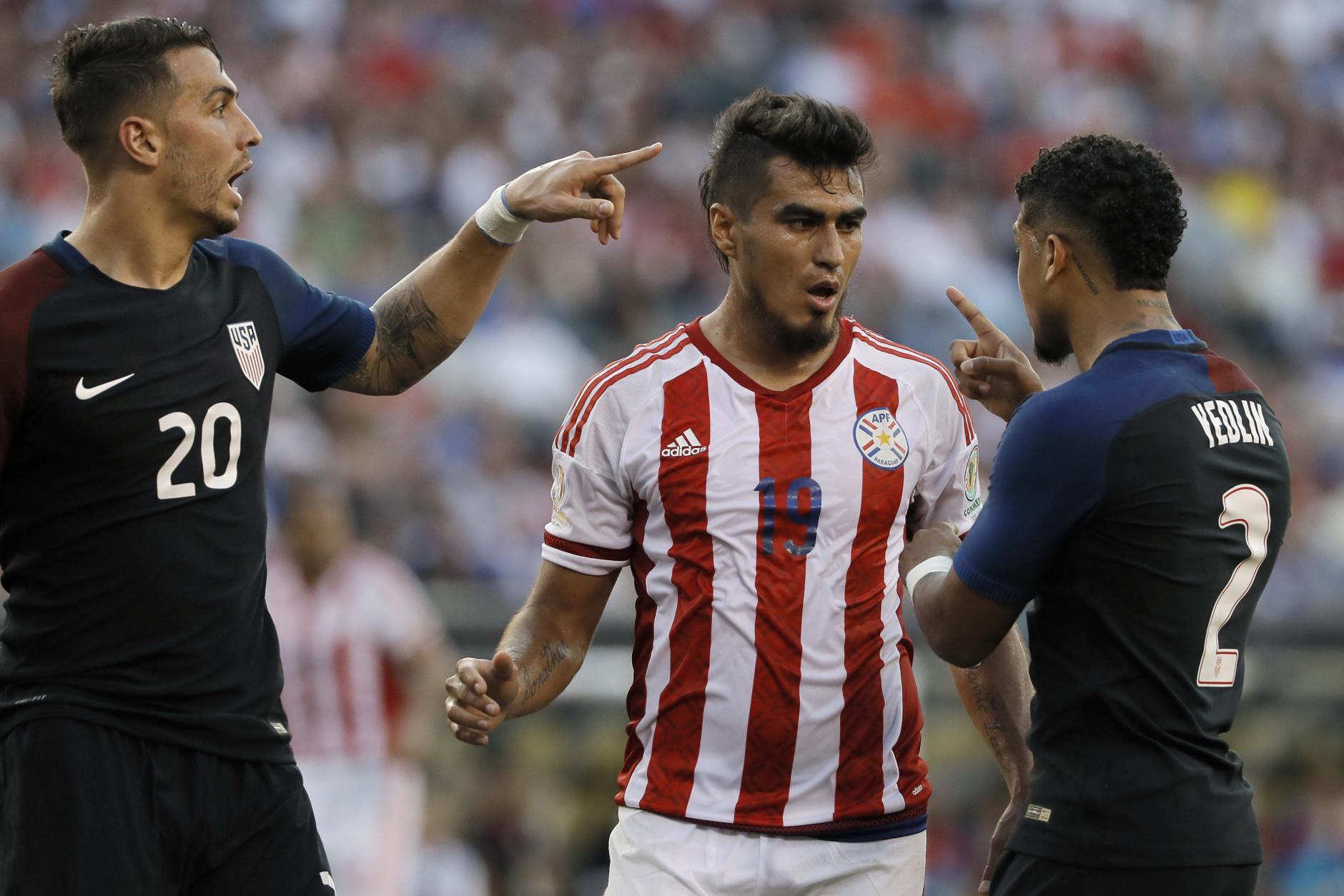 United States' Geoff Cameron, left, and DeAndre Yedlin, right, argue with Paraguay's Dario Lezcano after a tackle during the first half of a Copa America Group A soccer match Saturday, June 11, 2016, in Philadelphia. United States won 1-0. (AP Photo/Matt Slocum)