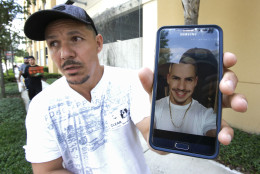 Angel Mendez, standing outside the Orlando Regional Medical Center, holds up a cell phone photo trying to get information about his brother Jean C. Mendez that was at the Pulse Nightclub where a shooting involving multiple fatalities occurred, Sunday, June 12, 2016, in Orlando, Fla. (AP Photo/John Raoux)