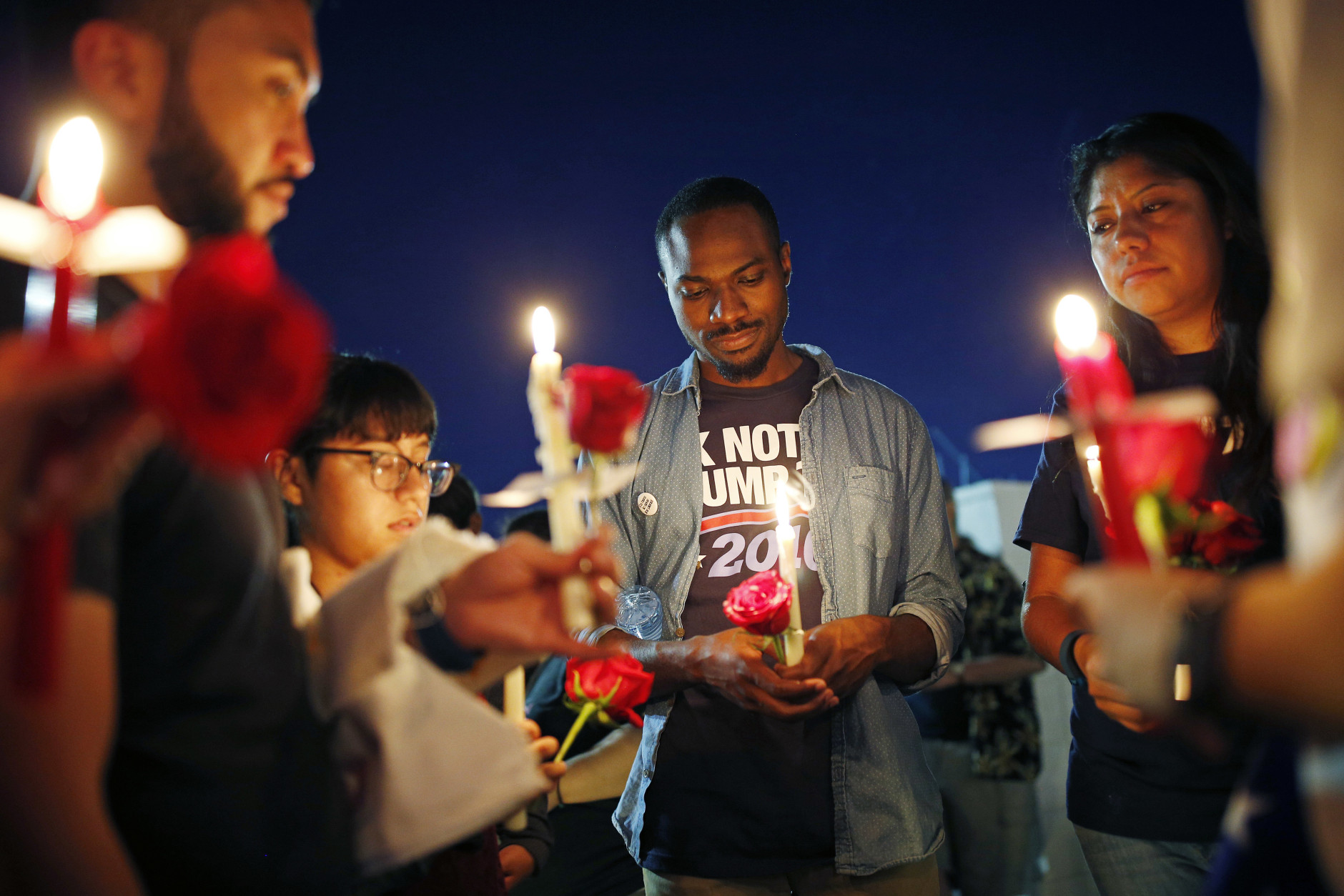 Maurice Forbes, center, holds a candle with others during a vigil at The Center, a community center for the LGBT community, Sunday, June 12, 2016, in Las Vegas. The vigil was for the victims of the Pulse nightclub shooting in Orlando. (AP Photo/John Locher)