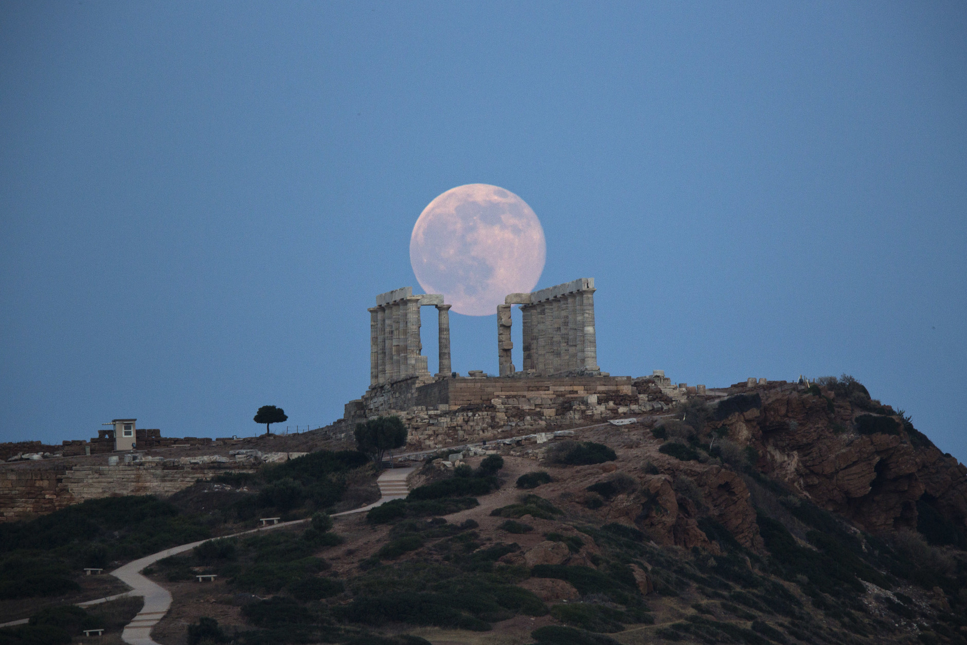 The full moon rises behind the columns of the ancient marble Temple of Poseidon at Cape Sounion, southeast of Athens, on the eve of the summer solstice on June 20, 2016.  The temple located on a promontory at Cape Sounion,  about 70 Km (45 miles) south-southeast of Athens, built 444 BC, and dedicated to Poseidon, god of the sea. (AP Photo/Petros Giannakouris)