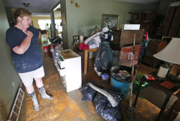 Kelly Vaughan looks over flood damaged belongings in her fathers home as they clean up from severe flooding in White Sulphur Springs, W. Va., Friday, June 24, 2016. There were several fatalities around the state. (AP Photo/Steve Helber)