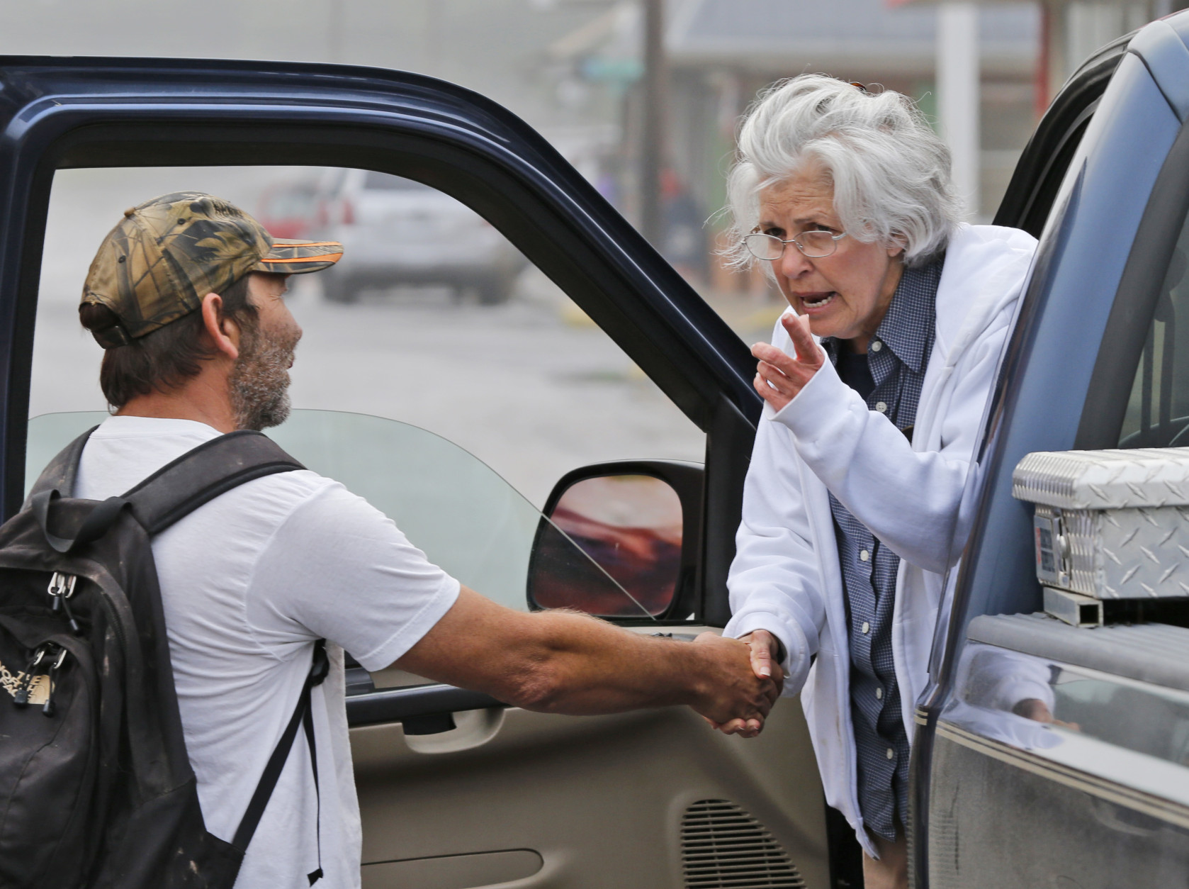 Rainelle W.Va. Mayor, Andrea Pendleton, right, talks to resident Nicholas Remick as she tours the flooded streets of Rainelle, W. Va., Saturday, June 25, 2016. Heavy rains that pummeled West Virginia left multiple people dead, and authorities said Saturday that an unknown number of people in the hardest-hit county remained unaccounted for.  (AP Photo/Steve Helber)