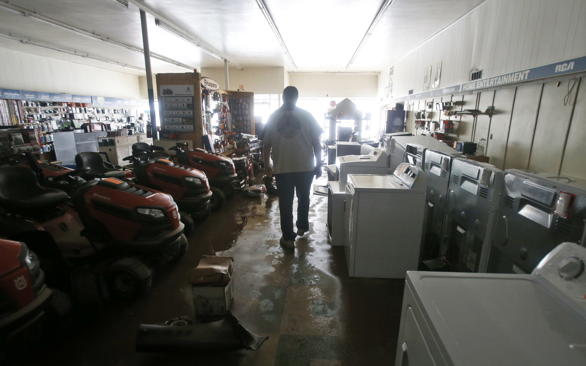 Paul Raines walks through his flooded Western Auto store in Rainelle, W. Va., Saturday, June 25, 2016. Heavy rains that pummeled West Virginia left multiple people dead, and authorities said Saturday that an unknown number of people in the hardest-hit county remained unaccounted for. (AP Photo/Steve Helber)