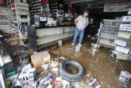 Paul Raines looks over his flooded Western Auto store in Rainelle, W. Va., Saturday, June 25, 2016. Heavy rains that pummeled West Virginia left multiple people dead, and authorities said Saturday that an unknown number of people in the hardest-hit county remained unaccounted for.  (AP Photo/Steve Helber)