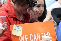 Madeline Scholl with the group Moms Demand Action for Gun Sense in America reacts Sunday, June 12, 2016, during a vigil in Anchorage, Alaska, to honor the victims of the attack on the gay nightclub in Orlando, Fla. The Alaska event was organized by Identity Inc. and Christians for Equality. (AP Photo/Mark Thiessen).