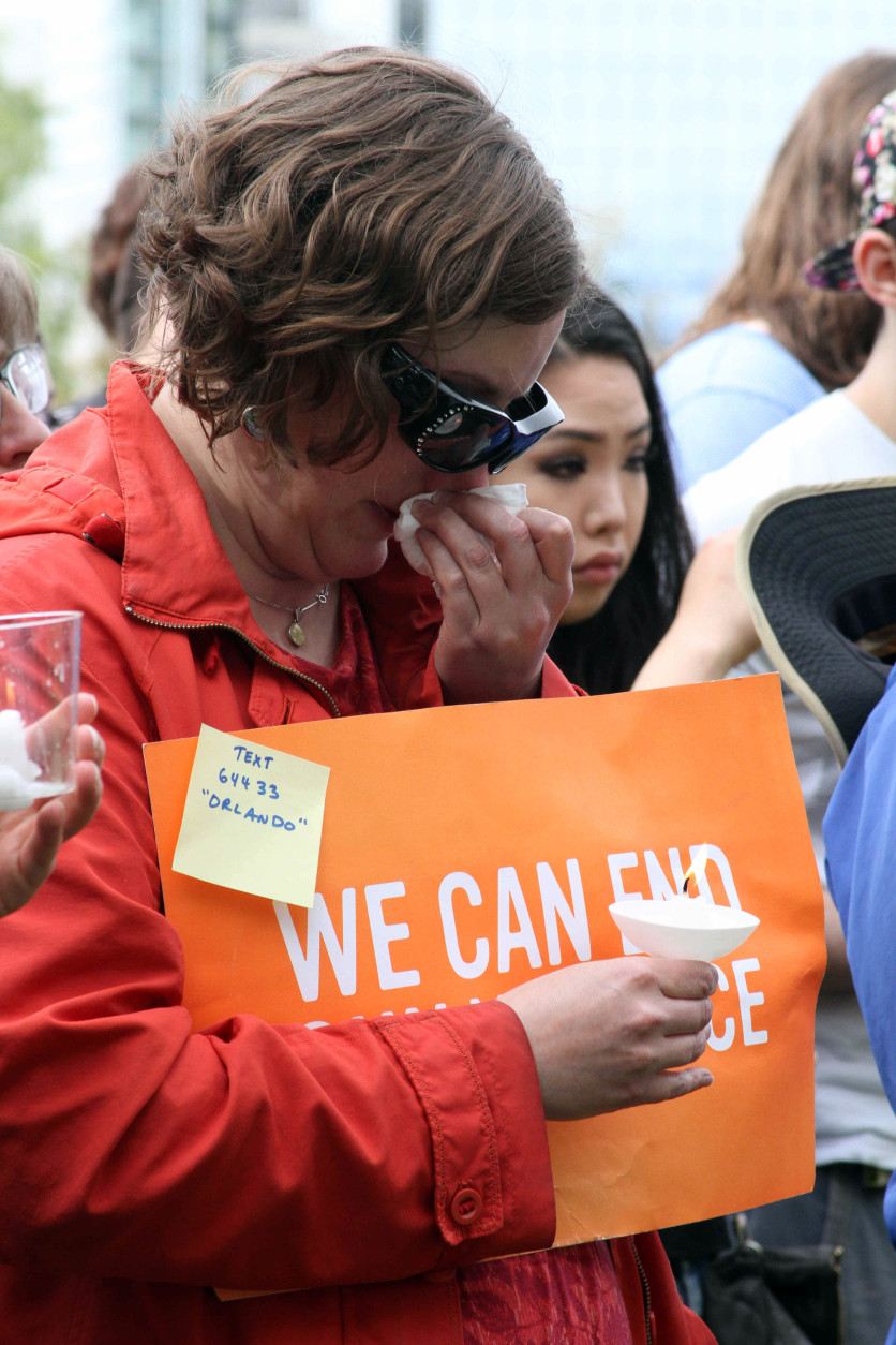 Madeline Scholl with the group Moms Demand Action for Gun Sense in America reacts Sunday, June 12, 2016, during a vigil in Anchorage, Alaska, to honor the victims of the attack on the gay nightclub in Orlando, Fla. The Alaska event was organized by Identity Inc. and Christians for Equality. (AP Photo/Mark Thiessen).