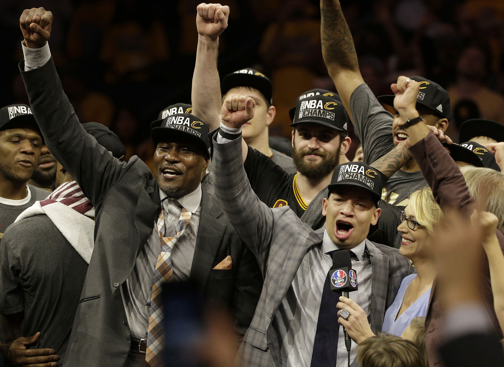 Cleveland Cavaliers head coach Tyronn Lue, second from right on bottom, celebrates after Game 7 of basketball's NBA Finals against the Golden State Warriors in Oakland, Calif., Sunday, June 19, 2016. The Cavaliers won 93-89. (AP Photo/Marcio Jose Sanchez)