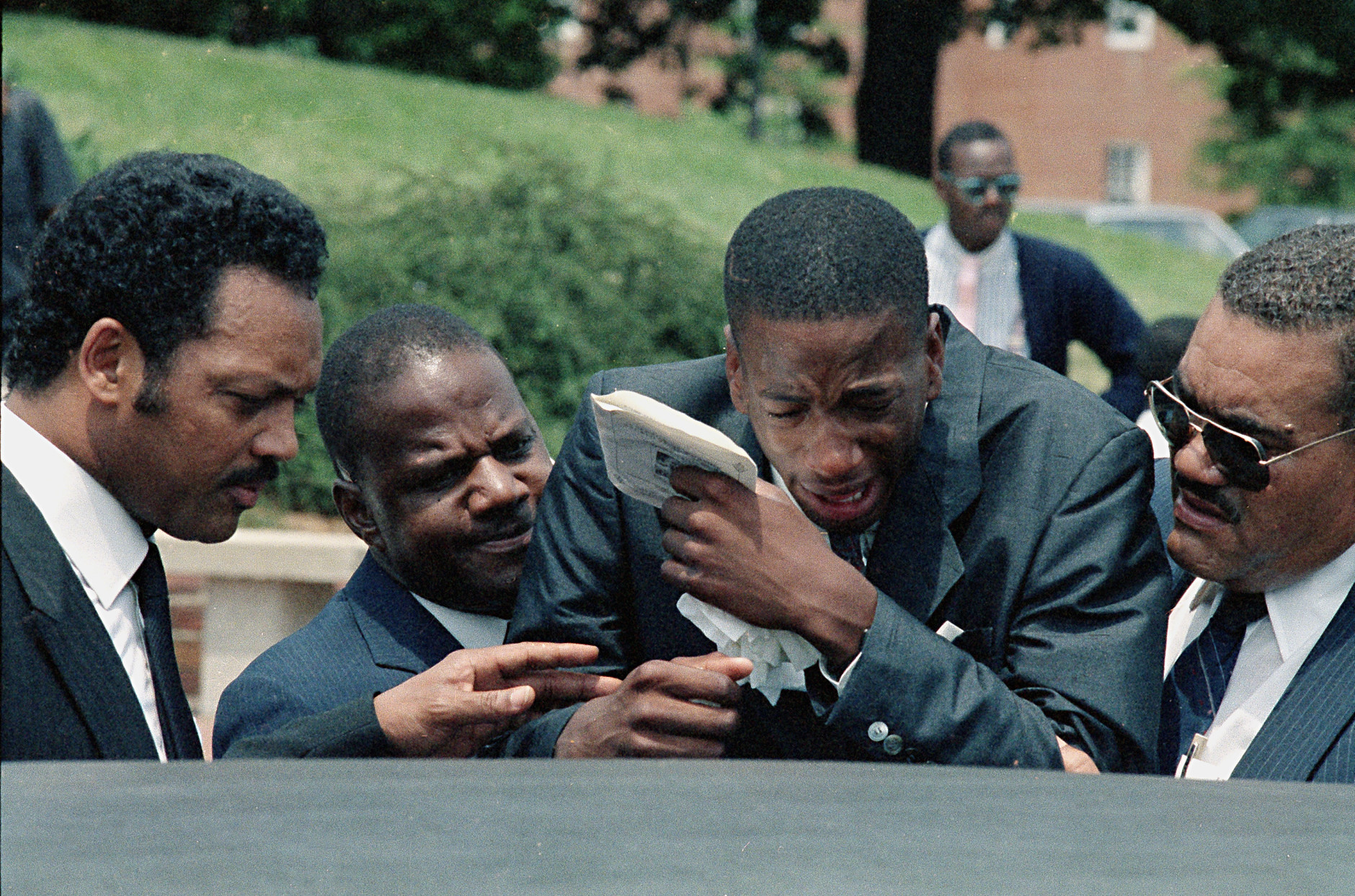 James Bias, Jr., right, brother of Len Bias, is comforted by his father James Bias and the Rev. Jesse Jackson after a private funeral service for the college basketball star at the University of Maryland, June 23, 1986.  Bias died of a heart attack on Thursday.  (AP Photo/Bill Smith)