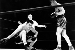 Jim Braddock slumps to the canvas and extends his glove for an easy fall in the championship bout with Joe Louis as Referee Tommy Thomas  watches the outgoing title-holder sink in Chicago, Ill. on June 22, 1937.  (AP Photo)