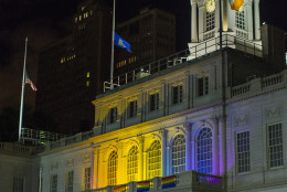 The New York City Hall building is illuminated in the colors of the LGBT pride flag in honor of the victims of the mass shooting in Orlando, Florida, in New York, Sunday, June 12, 2016. A gunman wielding an assault-type rifle and a handgun opened fire inside a crowded gay nightclub early Sunday before dying in a gunfight with SWAT officers. (AP Photo/Andres Kudacki)