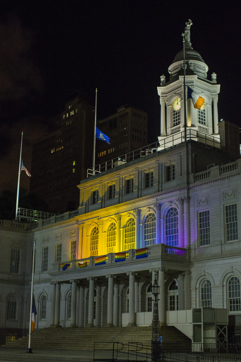 The New York City Hall building is illuminated in the colors of the LGBT pride flag in honor of the victims of the mass shooting in Orlando, Florida, in New York, Sunday, June 12, 2016. A gunman wielding an assault-type rifle and a handgun opened fire inside a crowded gay nightclub early Sunday before dying in a gunfight with SWAT officers. (AP Photo/Andres Kudacki)