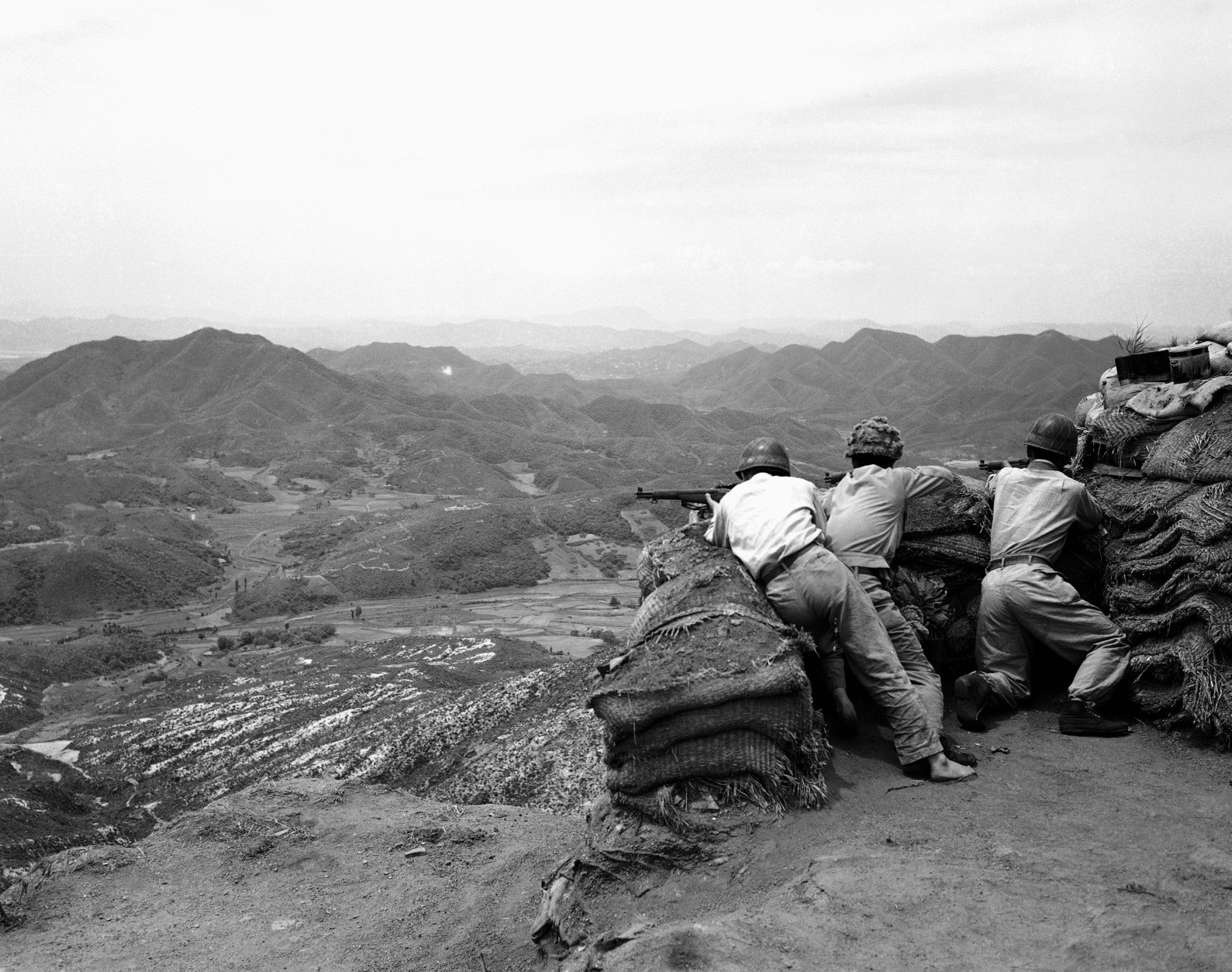Three South Korean riflemen man a position in the hills as they watch movement of Communist troops in the area beneath them. North Korean Communist troops on June 25, 1950 officially estimated at 50,000, invaded the American-sponsored South Korean republic. Early reports said the surprise onslaught by the Russian-trained North Koreans was supported by tanks and heavy artillery. (AP Photo)