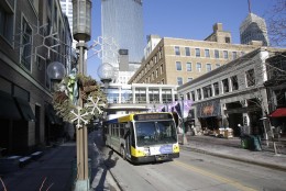 In this Tuesday, Feb. 12, 2013 photo, a bus moves past Minneapolis bustling downtown Nicollet Mall. The Twin Cities array of theaters and first-class museums, the states expansive parkland and its 19 Fortune 500 company headquarters _ the second-most per capita in the country _are frequently touted selling points in attracting talented people. Gov. Mark Dayton's proposed tax increases would primarily hit company ledgers _ just as many other governors, Republicans and even some Democrats, are trying to cut their income taxes and make other changes to attract businesses. (AP Photo/Jim Mone)