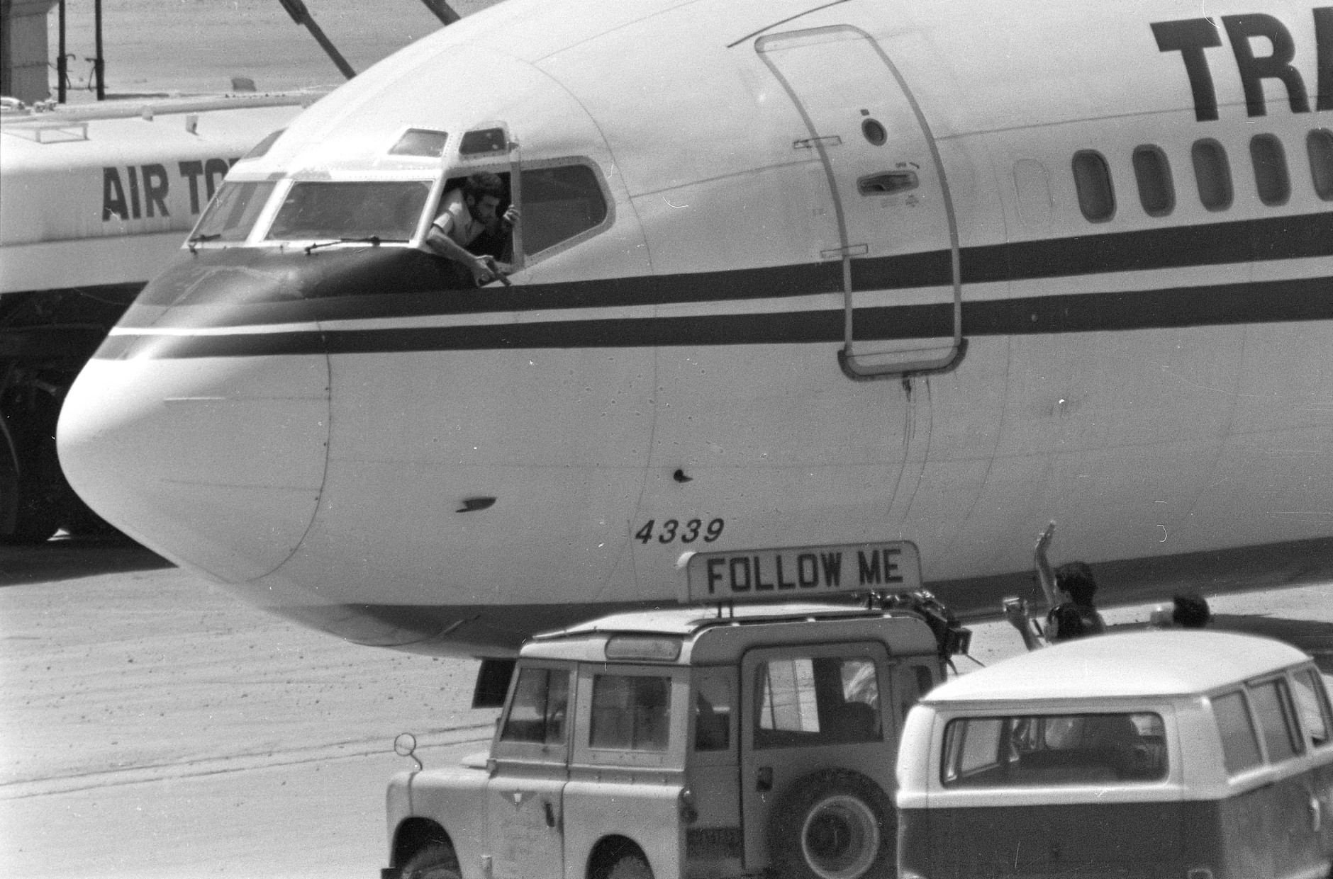 A Shiite Muslim hijacker points his pistol toward an ABC news media crew from the window of the cockpit of the Trans World Airlines jet as the American television crew approaches the jet for an interview at Beirut International Airport, Lebanon, June 19, 1985.  Gunmen hijacked TWA flight 847 carrying 153 people on June 14.  The ordeal lasted 17 days, with one passenger killed.  (AP Photo/Herve Merliac)