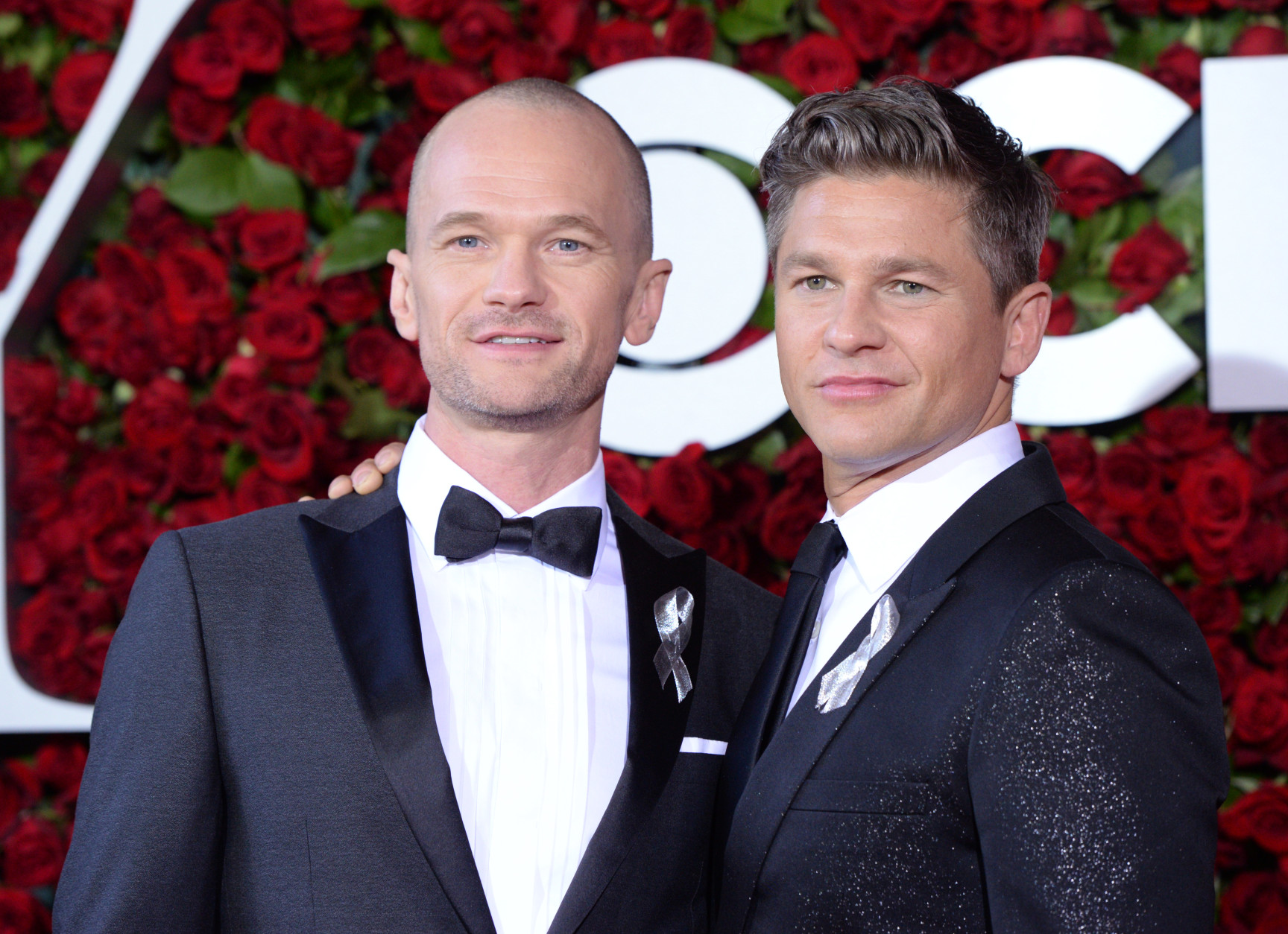 Neil Patrick Harris, left, and David Burtka wear silver ribbons as they arrive at the Tony Awards at the Beacon Theatre on Sunday, June 12, 2016, in New York. (Photo by Charles Sykes/Invision/AP)