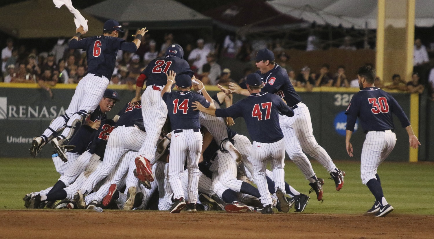 Arizona players celebrate after defeating Mississippi State 6-5 in 11 innings during an NCAA college baseball tournament super regional game in Starkville, Miss., Saturday, June 11, 2016. (AP Photo/Jim Lytle)