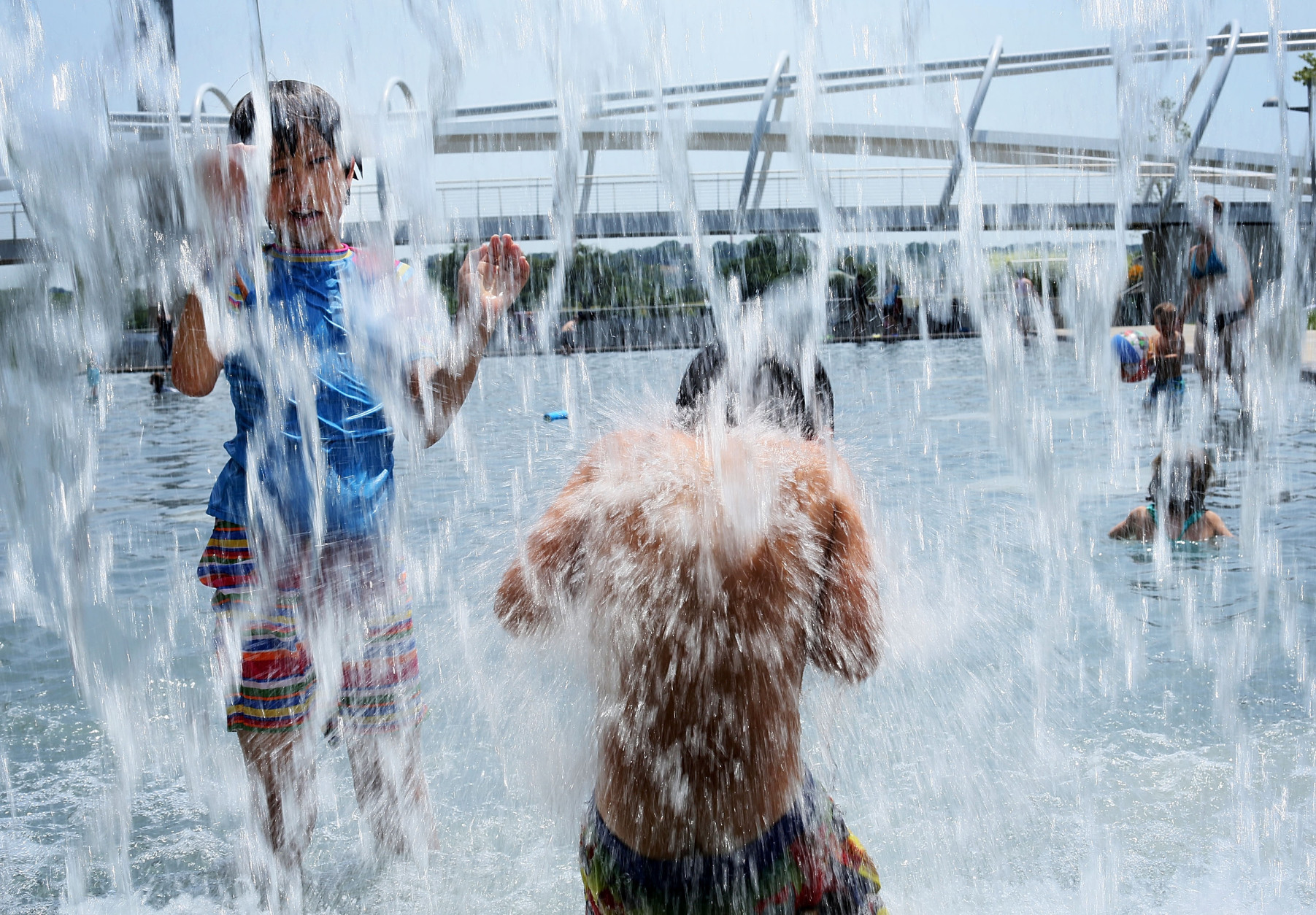 WASHINGTON, DC - JULY 05:  Ten-year-old Lilly Hwang-Geddes (L) of Ithaca, New York, plays in a fountain at the Yards Park July 5, 2012 in Washington, DC. A record heat wave has been in the area for more than a week. Weather forecast predicted the hot weather will last through Sunday with possible daily triple-digit temperature.  (Photo by Alex Wong/Getty Images)