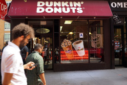NEW YORK, NY - AUGUST 26: People walk by a Dunkin' Donuts store on August 26, 2013 in New York City. Due to minimum wage and overtime violations, the U.S. Labor Department announced that the operator of 55 Dunkin' Donuts franchises in both New Jersey and on New York's Staten Island will  have to pay 64 employees nearly $200,000 in back wages. (Photo by Spencer Platt/Getty Images)