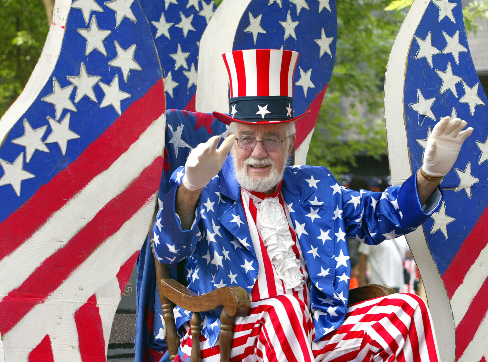 DES PLAINES, IL - JULY 3: A participant dressed in flag attire waves while riding on his float during the Fourth of July parade July 3, 2004 in Des Plaines, Illinois. America will celebrate its 228th birthday July 4, 2004. (Photo by Tim Boyle/Getty Images)