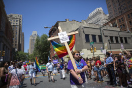 PHILADELPHIA, PA - JUNE 12: Austin Ellis, a member of Metropolitan Community Church, carries a cross with a sign in memory of the victims of the Pulse nightclub shooting as he marches in the 2016 Gay Pride Parade on June 12, 2016 in Philadelphia, Pennsylvania. 50 people were killed and 53 injured at the gay nightclub in Orlando, Florida early Sunday morning. (Photo by Jessica Kourkounis/Getty Images)